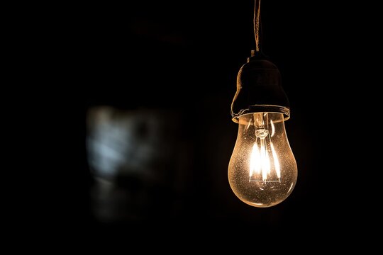 Hanging light bulb in darkness