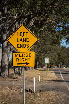 Orange left lane ends merge right sign with an arrow on the roadside