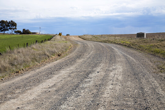 Unsealed dirt road winding up a hill