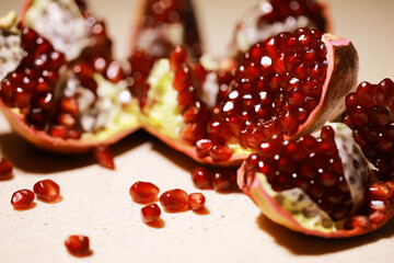 Fresh Pomegranate Seeds and Halves on Beige Background, Close-Up of Juicy Red Fruit
