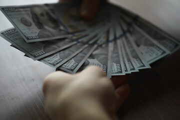 Hand Holding Fan of One Hundred Dollar Bills - Financial Success, Wealth, and Counting Money