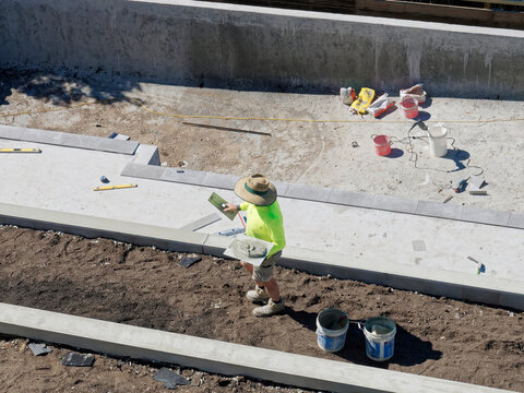 Concrete mixing and pool building with cement by hand with tradies