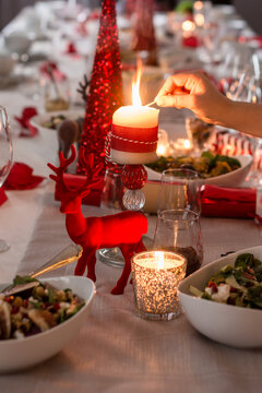 lighting candles on the Christmas dining table