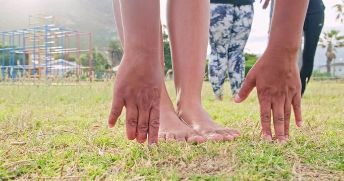 Low angle, hands, feet and grass. Touching toes for stretching and exercise. High quality 4k footage