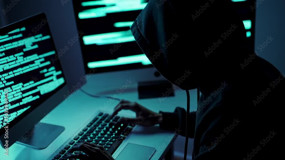 Poster Hooded cybercriminal typing malicious code in dimly lit environment, computer screen casting ominous light while executing potentially dangerous digital network infiltration