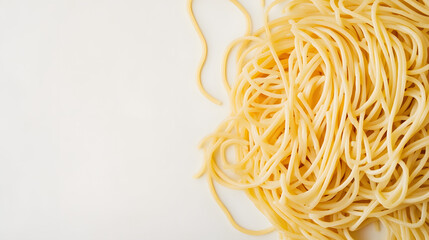 A pile of spaghetti noodles arranged casually on a white background, emphasizing their long, thin shape and texture.