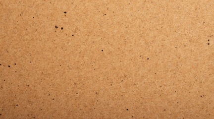 Close-up Texture of Natural Brown Kraft Paper with Speckles and Grain Patterns