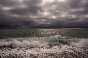 Dark storm clouds over ocean. Dramatic seascape. Clouds and rain flurry over sea.