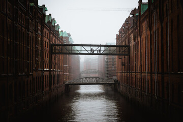 Fußgängerbrücke in der historischen Speicherstadt Hamburg bei Nebel. Stimmungsvolle Aufnahme der Hamburger Speicherstadt bei Nebel. Eine Fußgängerbrücke verbindet zwei historische Backsteingebäude übe