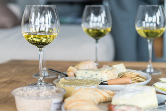 white wine in a glass, with cheeses and dips