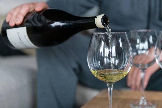 man pouring white wine