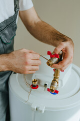 Worker's hands wrapping hemp sealing thread around a metal fitting