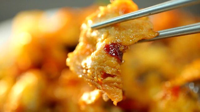 Chopsticks holding a piece of cooked meat