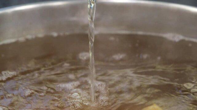 Ladle pouring broth into a pot