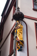 Sculpture of Virgin Mary and infant Jesus in golden robes on a building corner in Frankfurt,...