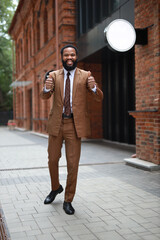 Obraz premium successful african businessman in suit with hand gesture