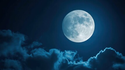 Full moon shining brightly amidst dark clouds in the serene night sky.