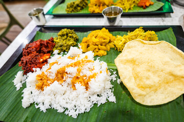 Banana Leaf Rice, Indian Street Food, Southern India dish. White steamed rice served with few types of vegetables and sauces, served on top of banana leaf as the plate.