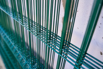 Welded mesh for fence in green color, several sections of transparent fence