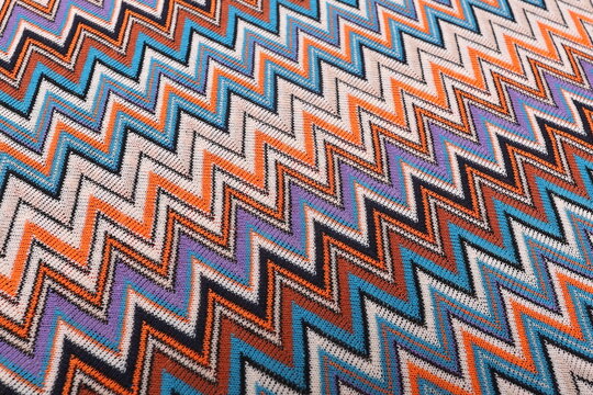 Top-down view of Missoni knit fabric showcasing its intricate texture and vibrant woven pattern. The premium material, known for its elasticity and elegance, is ideal for high-fashion garments.