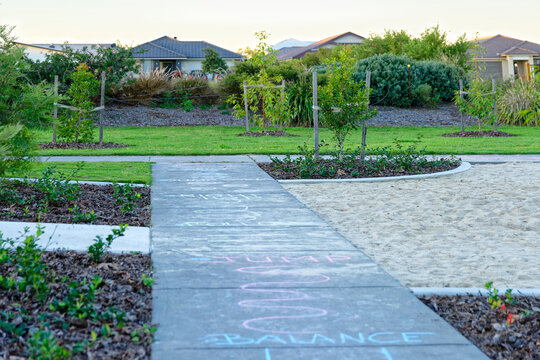Chalk drawings on the pavement at a play park at dusk