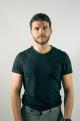 Young man standing confidently against a plain backdrop