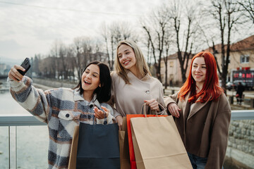 Group of three female friends walk home happy and excited with shopping bags	
