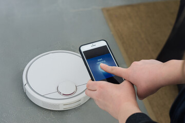woman using a photo to control a robotic vacuum cleaner
