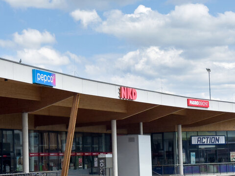 Shopping center facade with nkd pepco and pagro signs against cloudy sky