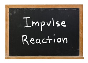 Impulse reaction written in white chalk on a black chalkboard