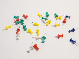 Colorful Thumbtacks Scattered on a White Background for Creative Projects