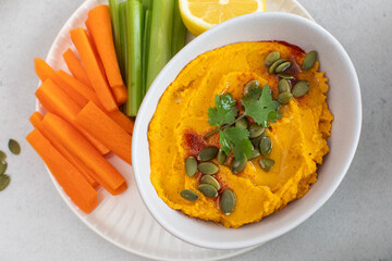 Healthy pumpkin hummus with fresh vegetables and pumpkin seeds for snack. Healthy food