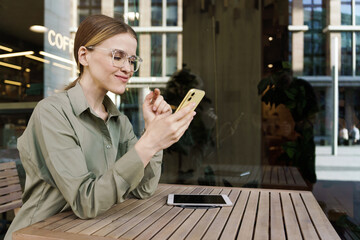 Engaging conversation unfolds in a busy urban cafe as a woman interacts with her smartphone