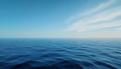 Obraz premium Calm sea under a blue sky with white clouds in horizontal composition.