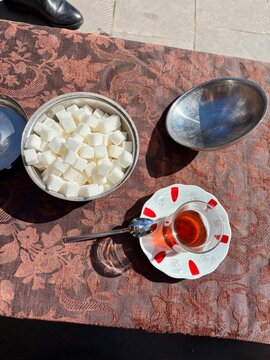 Turkish tea with sugar and spoon on traditional tablecoth