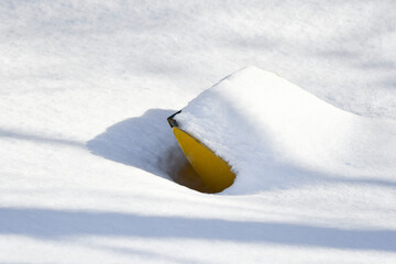 Yellow snow scoop under fresh snow