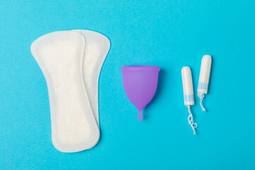 Menstrual cup on a bright background. Sanitary napkins, tampons and menstrual cup.Concept of critical days, menstruation.feminine hygiene product. Women health concept.Premenstrual syndrome.Copy space