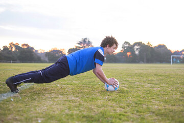 Teenage soccer player on a soccer pitch with ball