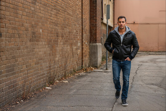 young man near the wall walking down the street