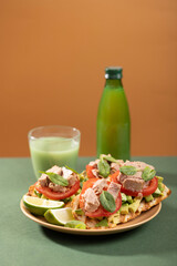 Tuna sandwiches on a table next to lemonade and beer, in a modern interior design