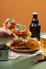Tuna sandwiches on a table next to lemonade and beer, in a modern interior design