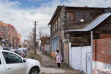 A woman walks past old 1902 two-story wooden apartment building in the center of Provincetown.
