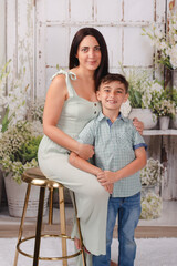 mother and son in green house posing for Mother's Day photos 