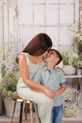 mother and son in green house posing for Mother's Day photos 