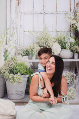 mother and son in green house posing for Mother's Day photos 