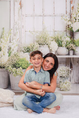 mother and son in green house posing for Mother's Day photos 