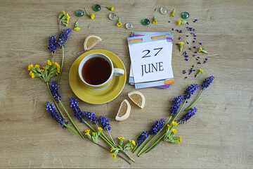 Calendar for June 27: the number 27 and the name of the month June in English on a flip calendar...