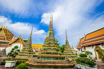 Fototapeta premium Beautiful pagoda of Wat Pho temple complex against blue sky sightseeing travel in Bangkok