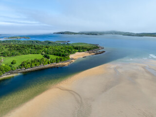 Idyllische Luftaufnahme von St. Catherine's Beach mit Wald und ruhigem Wasser Irland