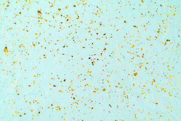 Golden glitter sparkles on blue holiday background. Festive backdrop.